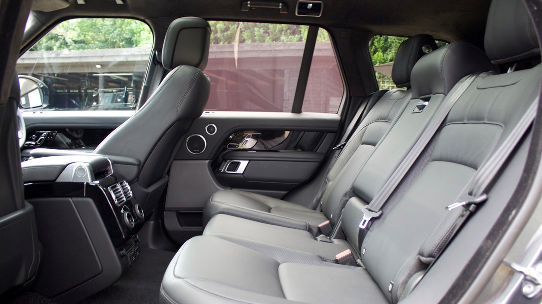 Black Range Rover rear seating area with black leather seats and ample legroom