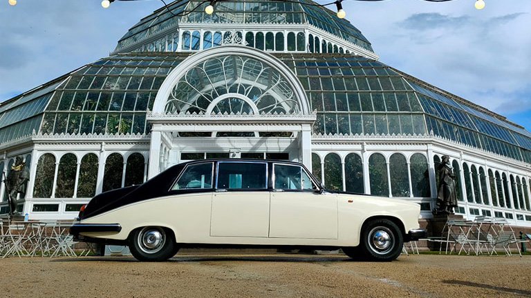 Classic Daimler DS420 Limousine parked in front of wedding venue.