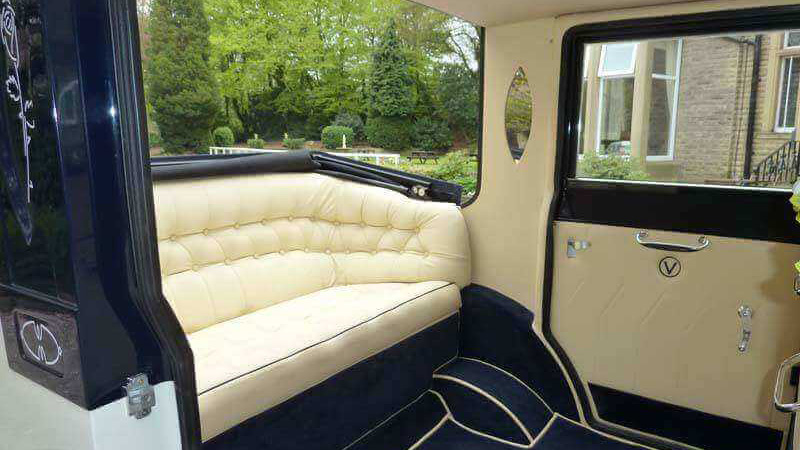 rear interior bench seat in cream inside a vintage imperial car