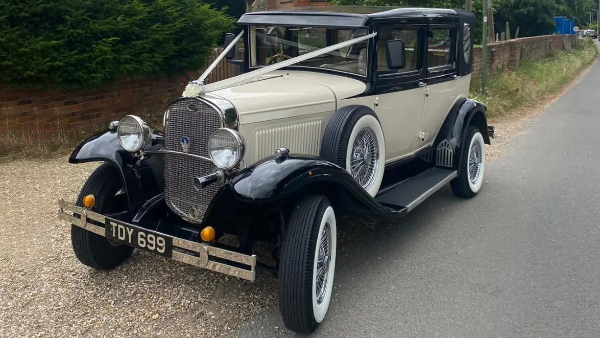 Badsworth Landaulette in Ivory with black wheel arches decorated with wedding ribbons