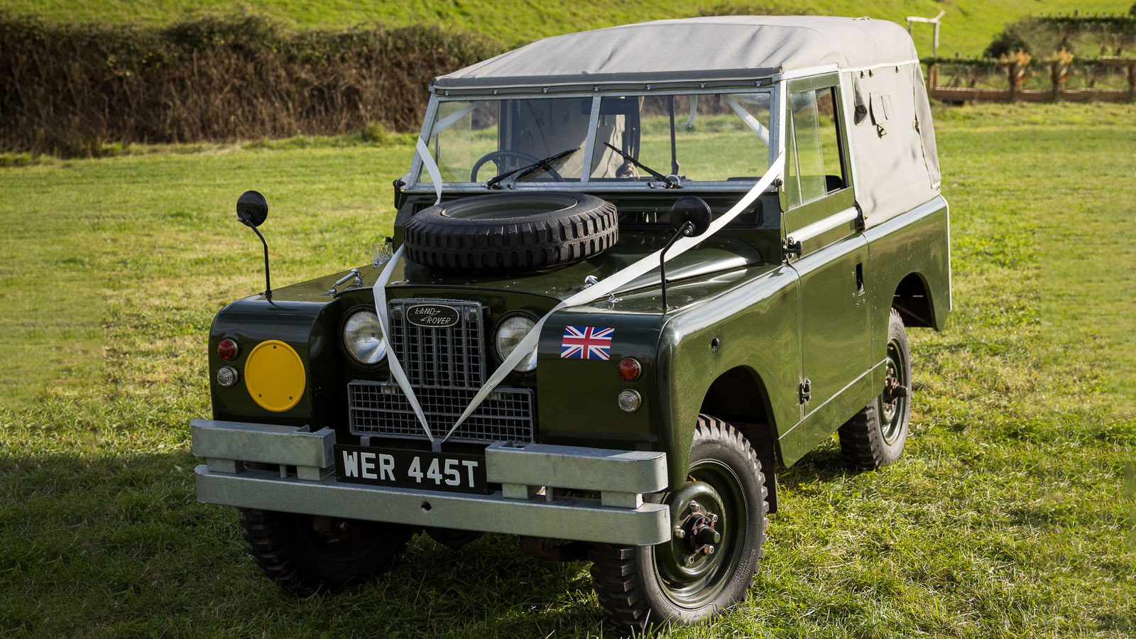 Classic Landrover Series 2 in Army Green with Light grey Canvas decorated with white wedding ribbons