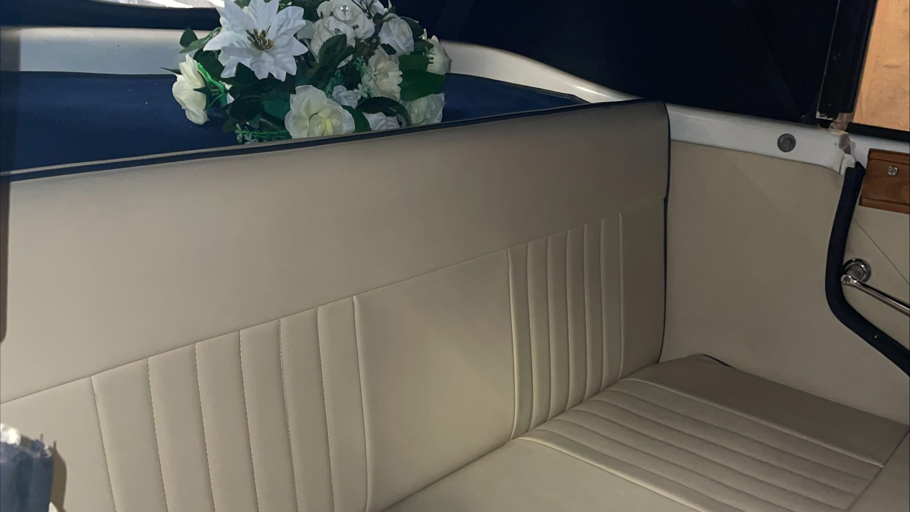 Rear cream leather bench seat inside Beauford with floral decoration on the rear parcel shelf.