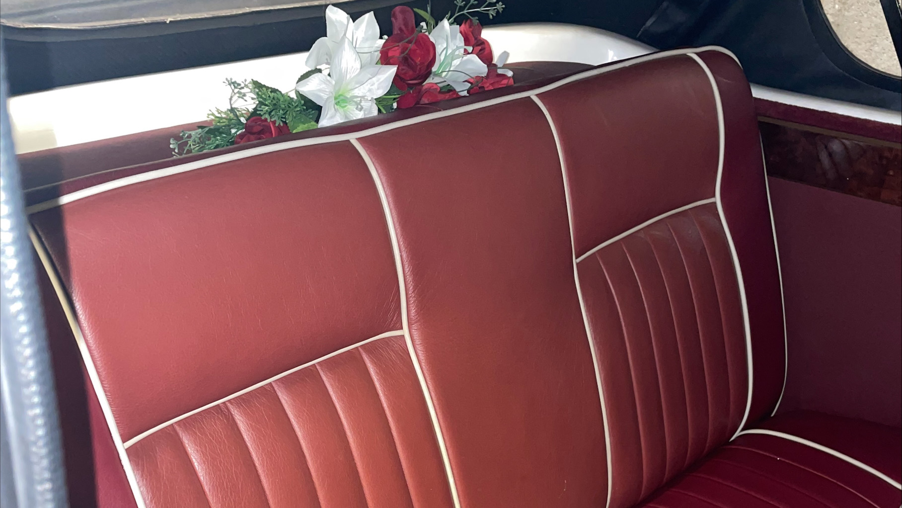 Maroon Leather rear bench seat inside Beauford and floral arrangement on the rear parcel shelf