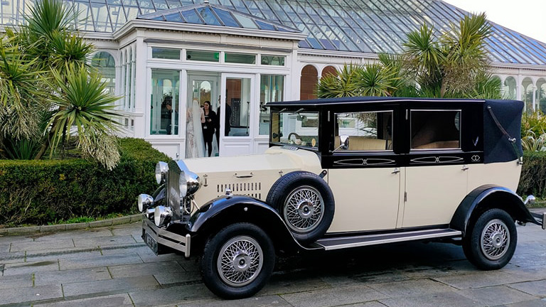 Left side view of a Black & Ivory Imperial wedding car in front of a wedding venue in Liverpool