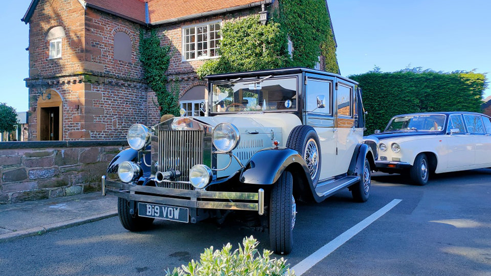 vintage wedding car in Black & Ivory following by a classic limousine in the same colour scheme