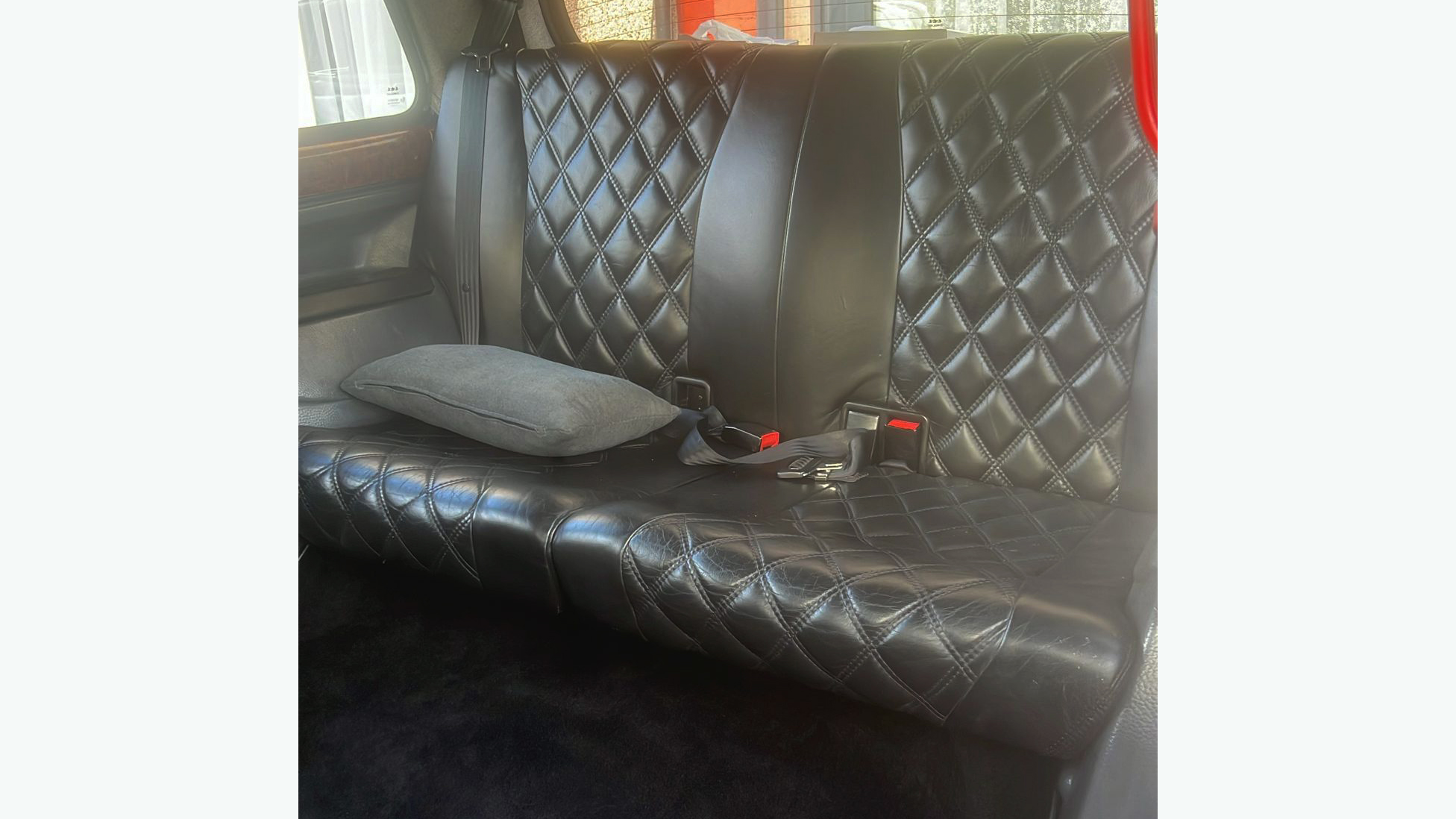 Black leather seats in the rear compartment of a Taxi Cab