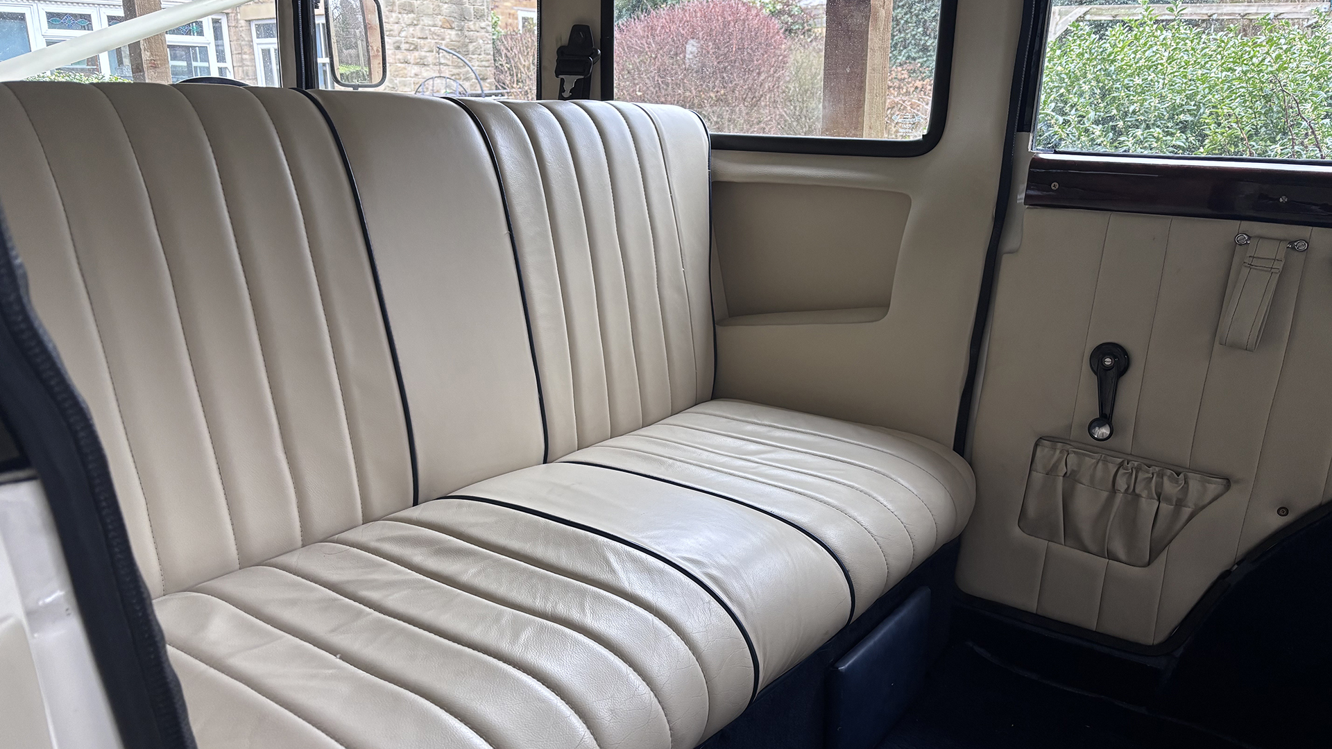 Cream leather rear bench seat inside a vintage Bramwith limousine