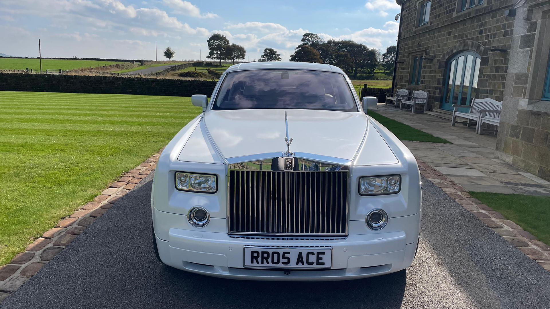 Full front view of white Rolls-Royce Phantom with large Chrome grill and spirit of ecstasy atop