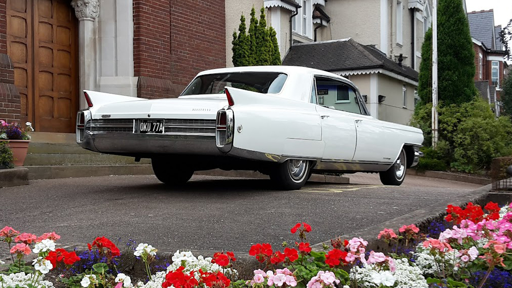 Rear view of White classic American Cadillac Fleetwood showing the rear fin tails chrome bumper