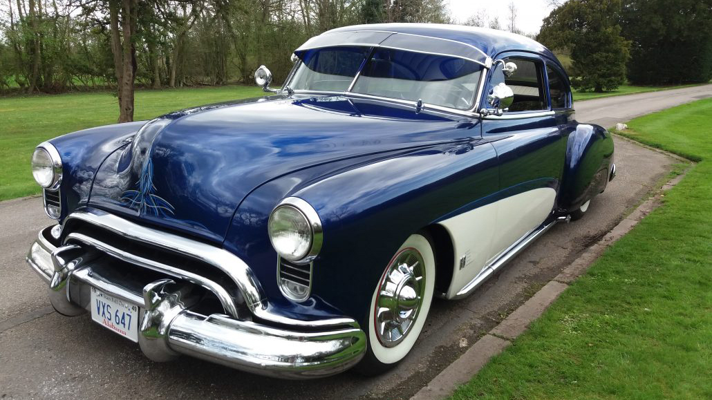 Classic American Oldsmobile Rocket 88 in White and Blue with Large chrome bumper, chrome wheels and white wall tires