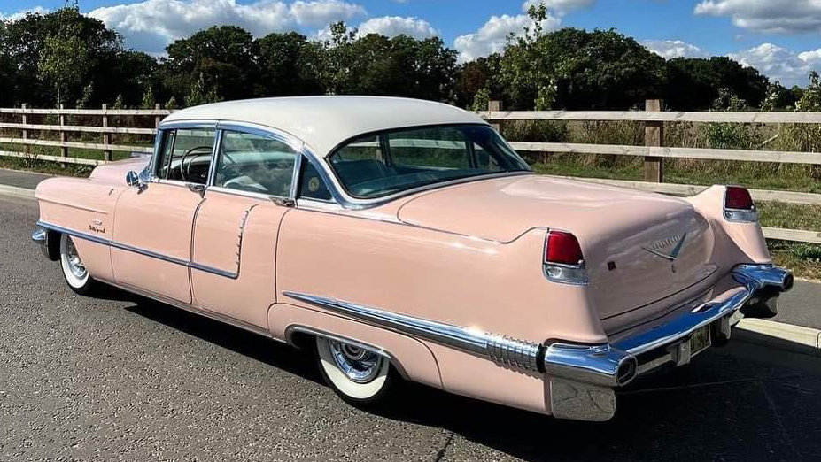 Left rear view of Classic Pink American Cadillac Fleetwood with white roof and large rear chrome bumper