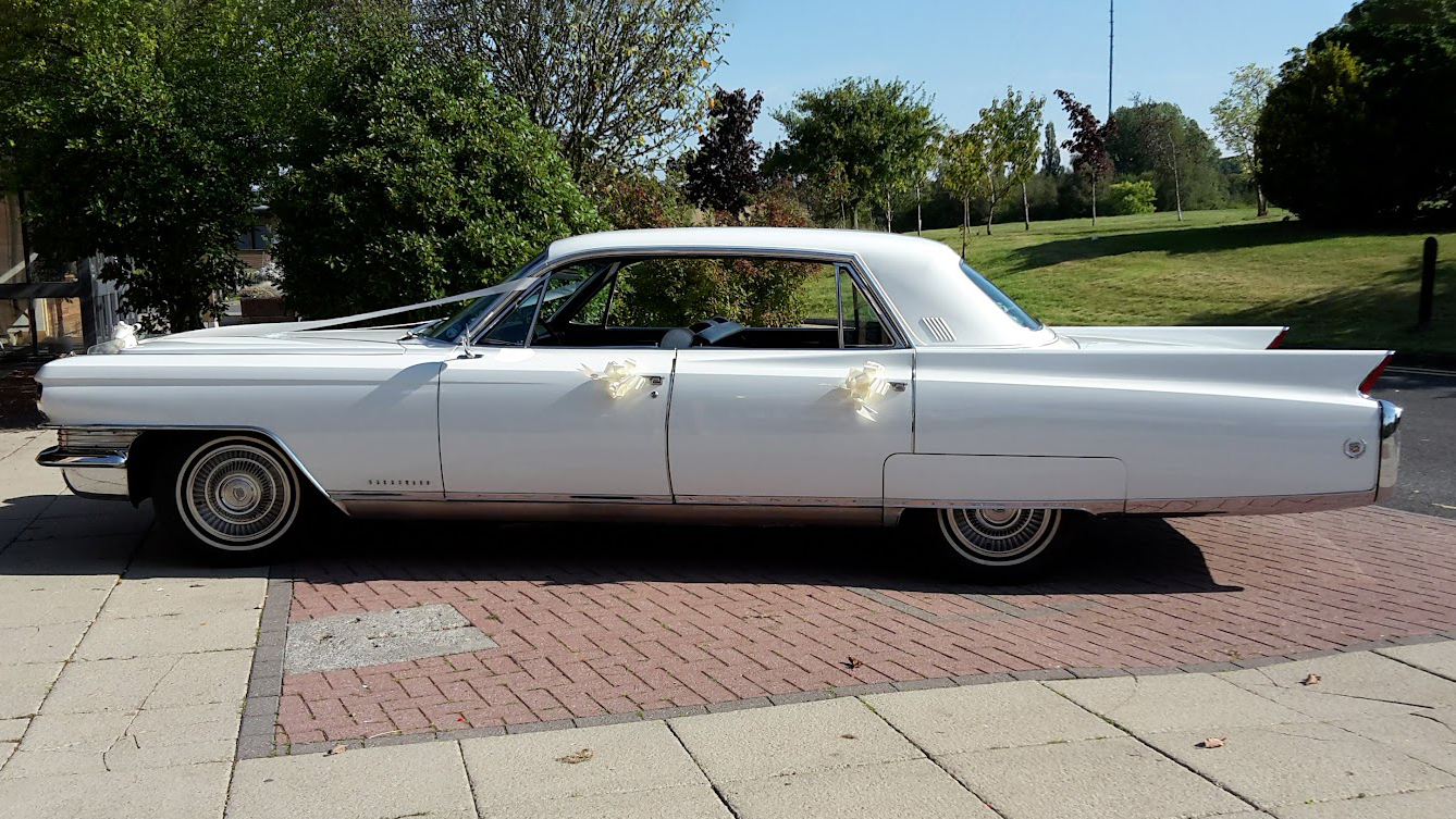 Left side view of White American Cadillac Fleetwood decorated with white ribbons and bows