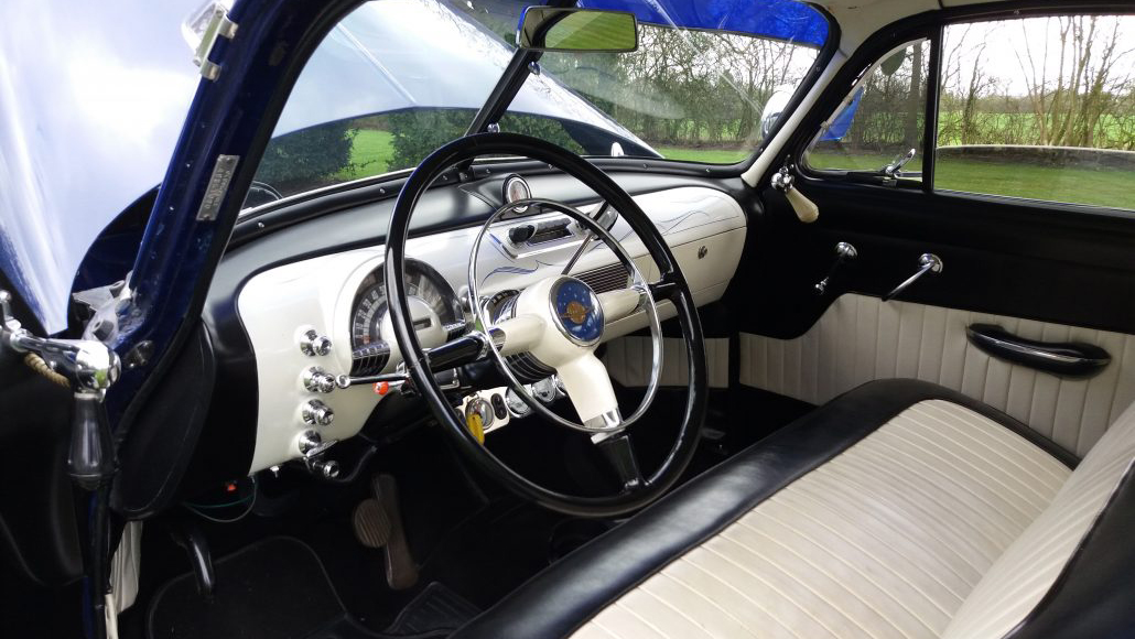 Oldsmobile Rocket 88 front interior view with bench seat in black and white and dashboard