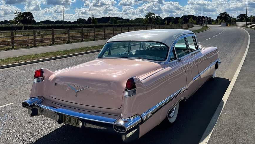 Rear view Classic Pink American Cadillac Fleetwood parked on the road