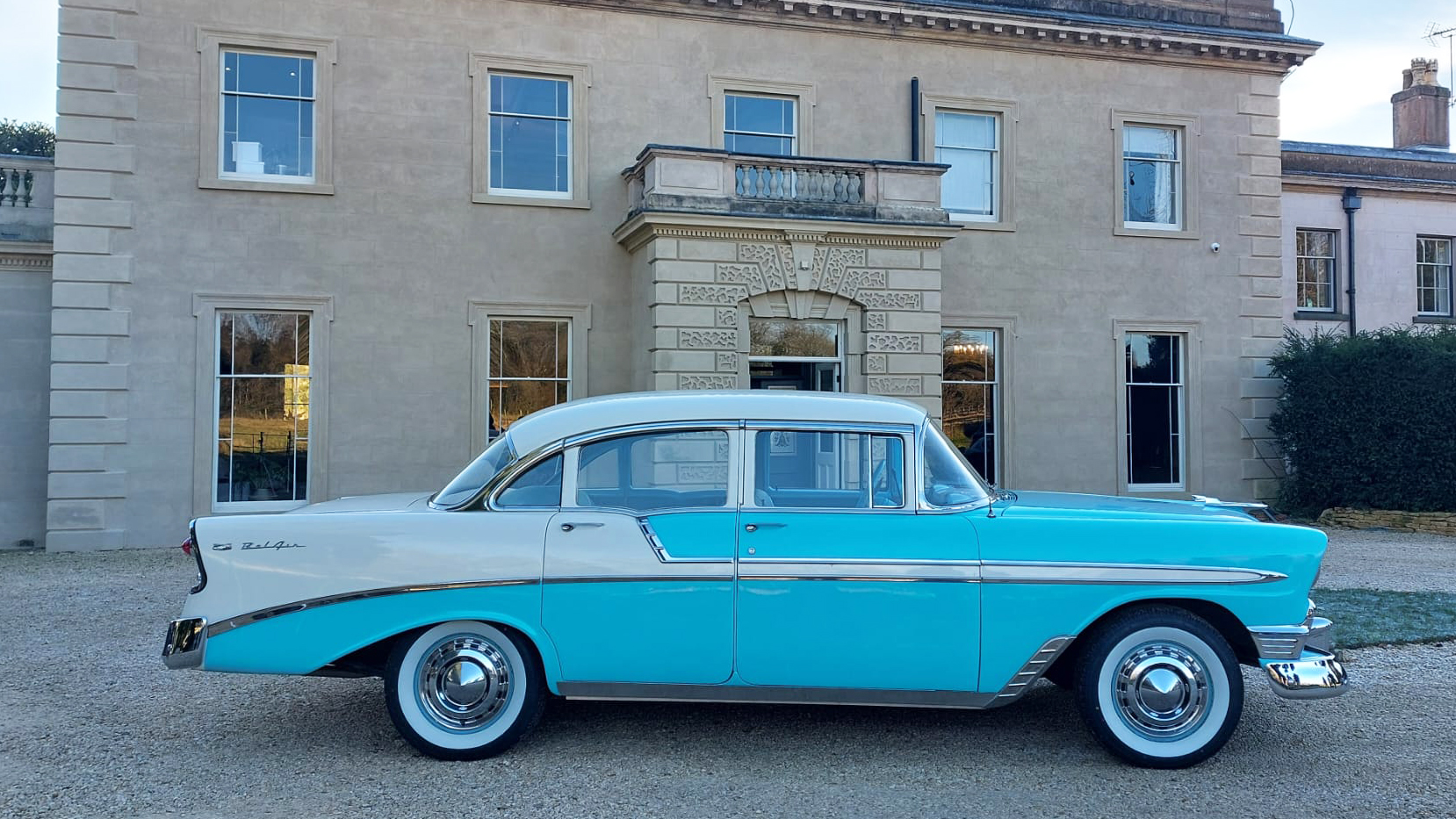 Right side view of American Chevrolet BelAir in Teal Blue and White parked outside wedding venue in Midlands