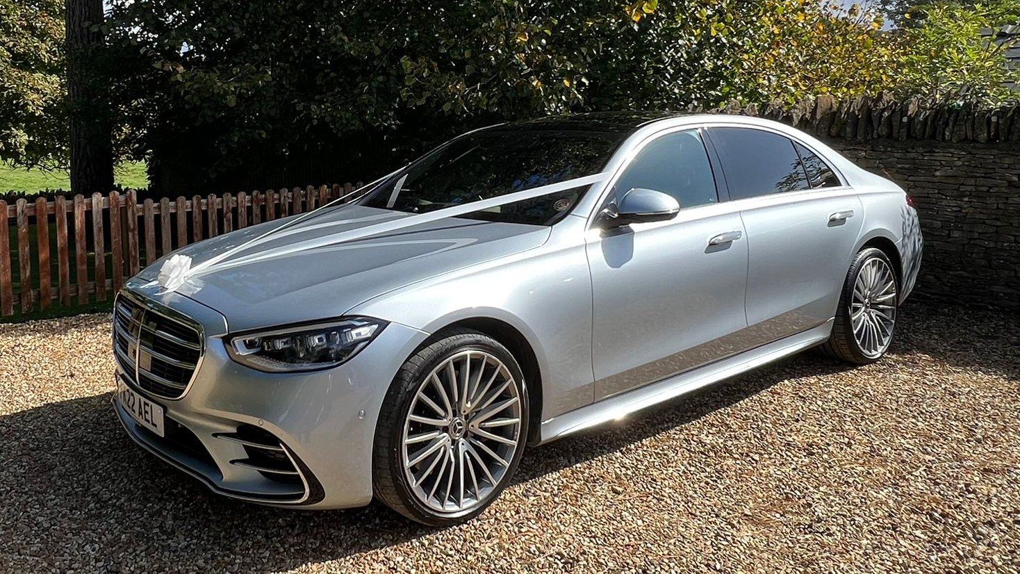 Left side view of Silver Mercedes with wedding ribbons and large chrome alloy wheels