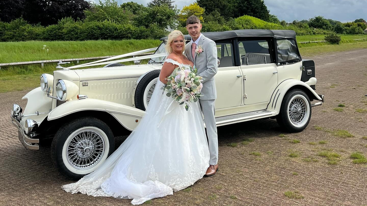 Bride and groom holding each others in front of an Ivory Beauford