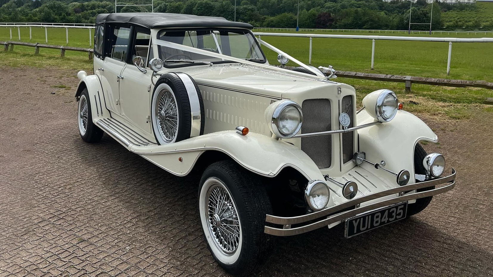 Front view of ivory BEauford with black soft top roof closed, chrome bumper and chrome spokes wheels