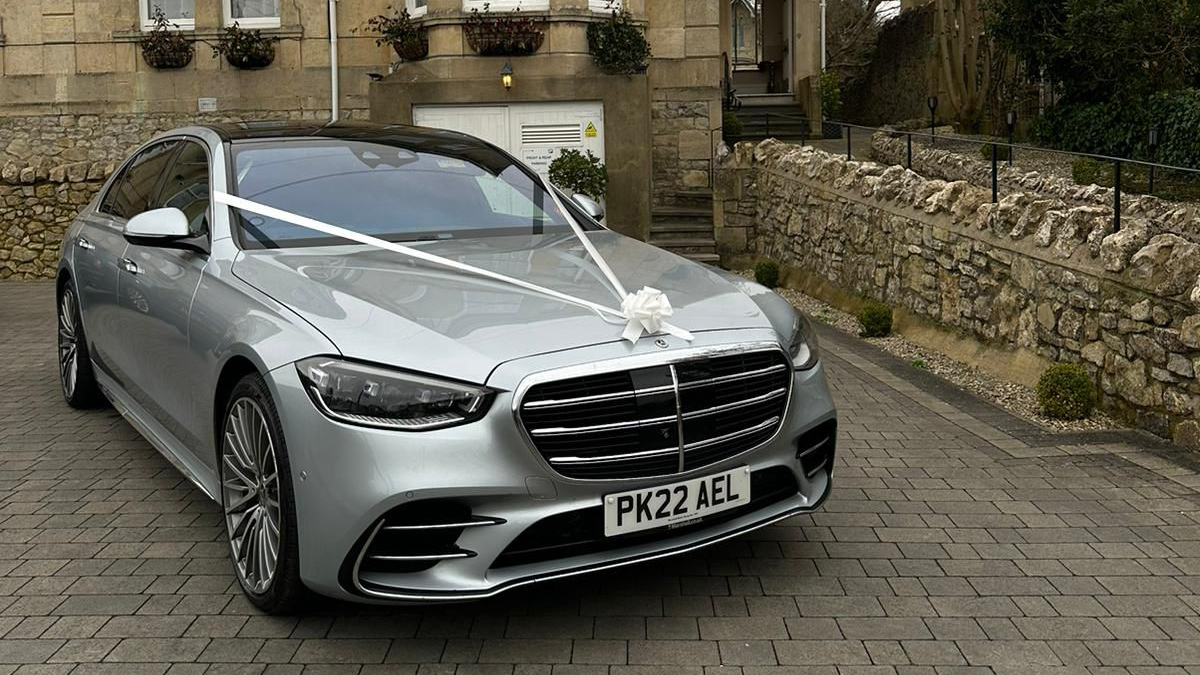 Front view of silver Mercedes decorated with wedding ribbons and bow