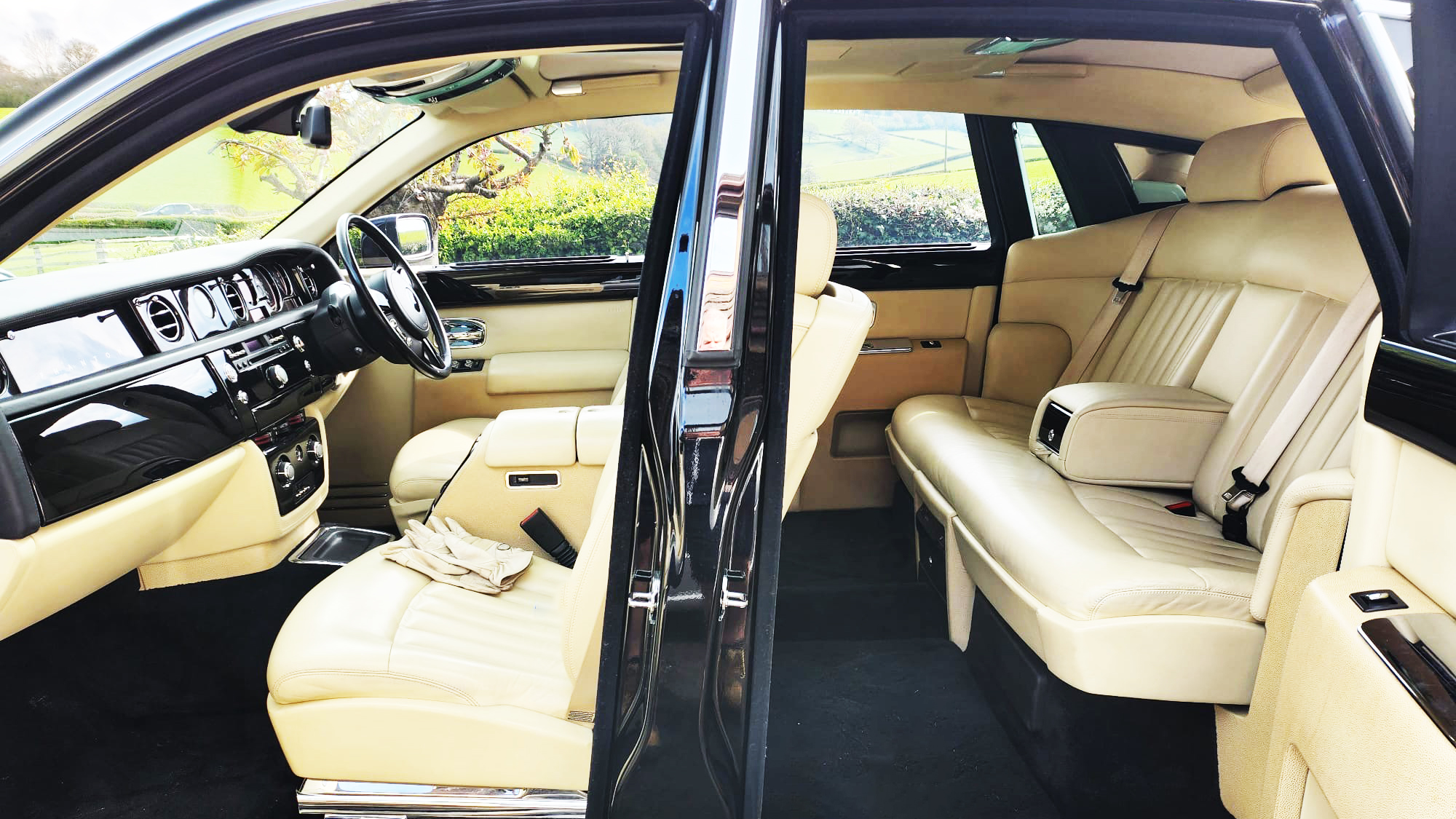 Left side doors open on a Rolls-Royce Phantom with "Coach Doors" showing cream leather seats and black carpet