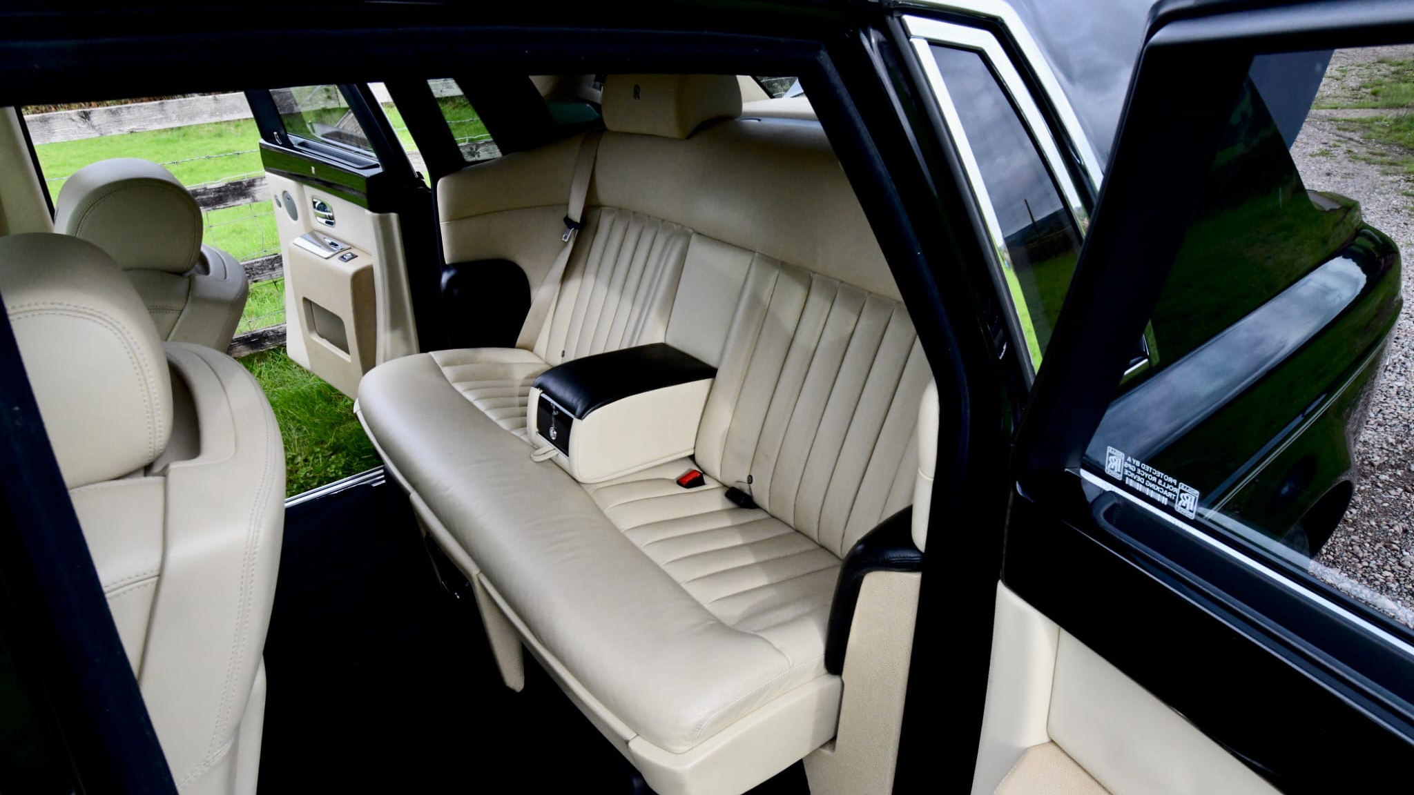 Black Rolls-Royce Phantom with door open showing cream leather rear seating area