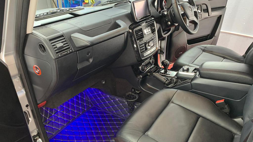 Front passenger seat inside Mercedes G-Wagon with illuminated LED lights in blue