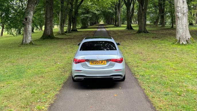 Rear view of silver Mercedes exiting wedding venue