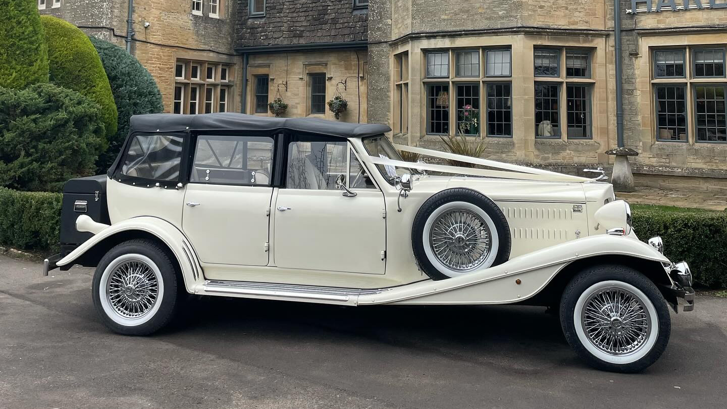 Right side view of Vintage Beauford with black soft top roof closed and spare wheel mounted on the side of the vehicle