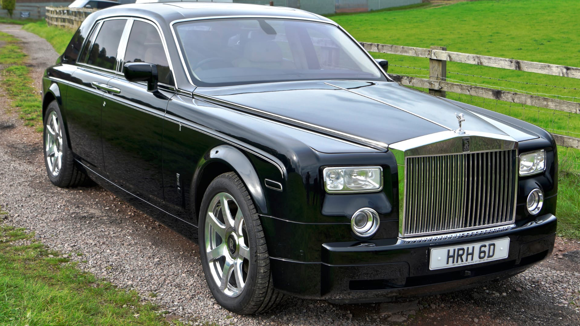 Black Rolls-Royce Phantom with large alloy wheels and tall chrome front grill