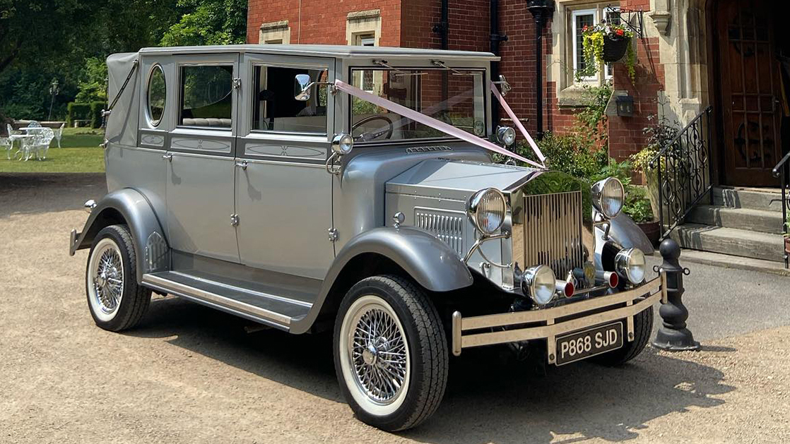 Front view of Imperial wedding car with wedding ribbon decoration parked in front of a Bristol venue