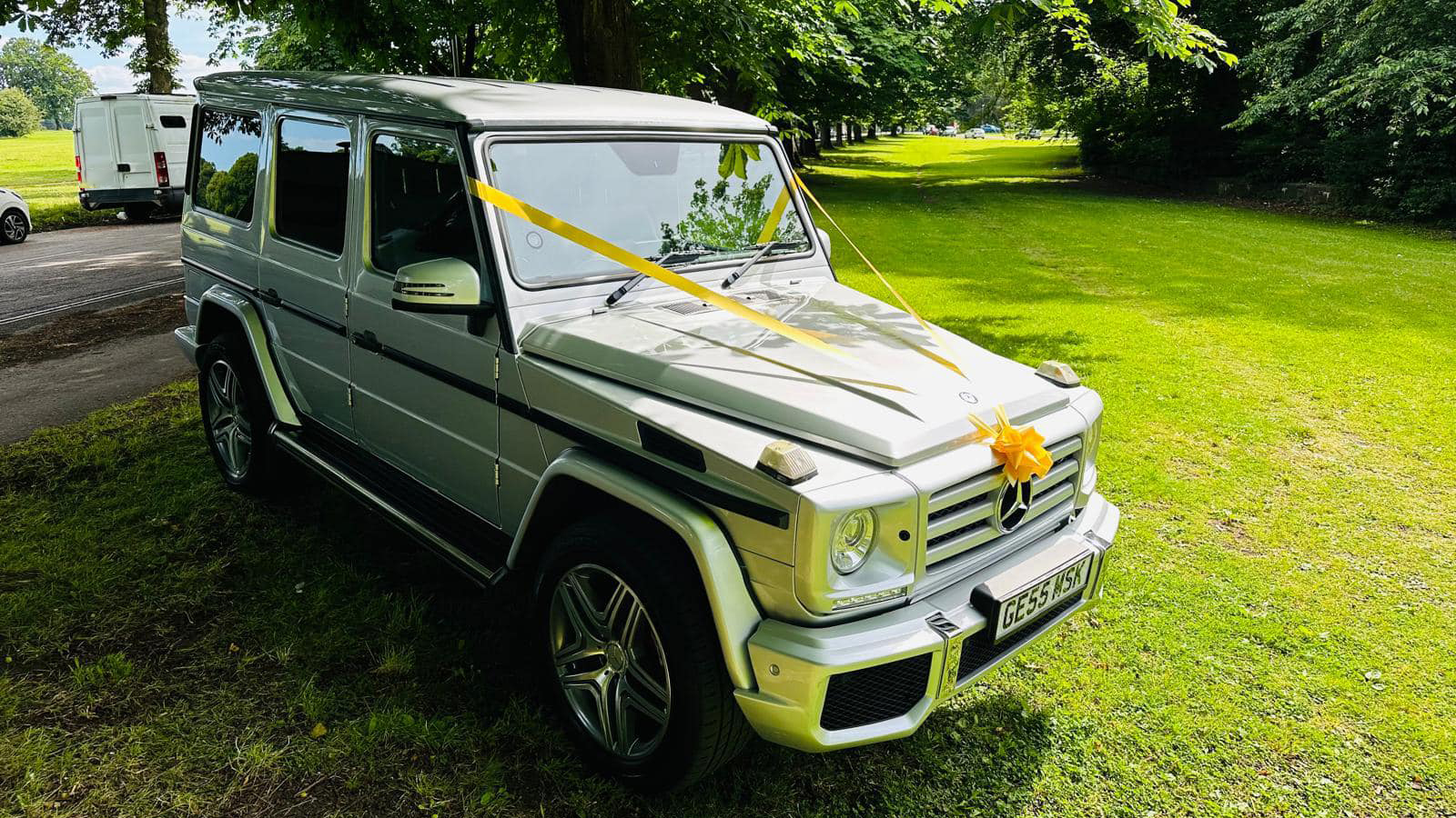 Right side view of a Mercedes G-Wagon with yellow wedding ribbons