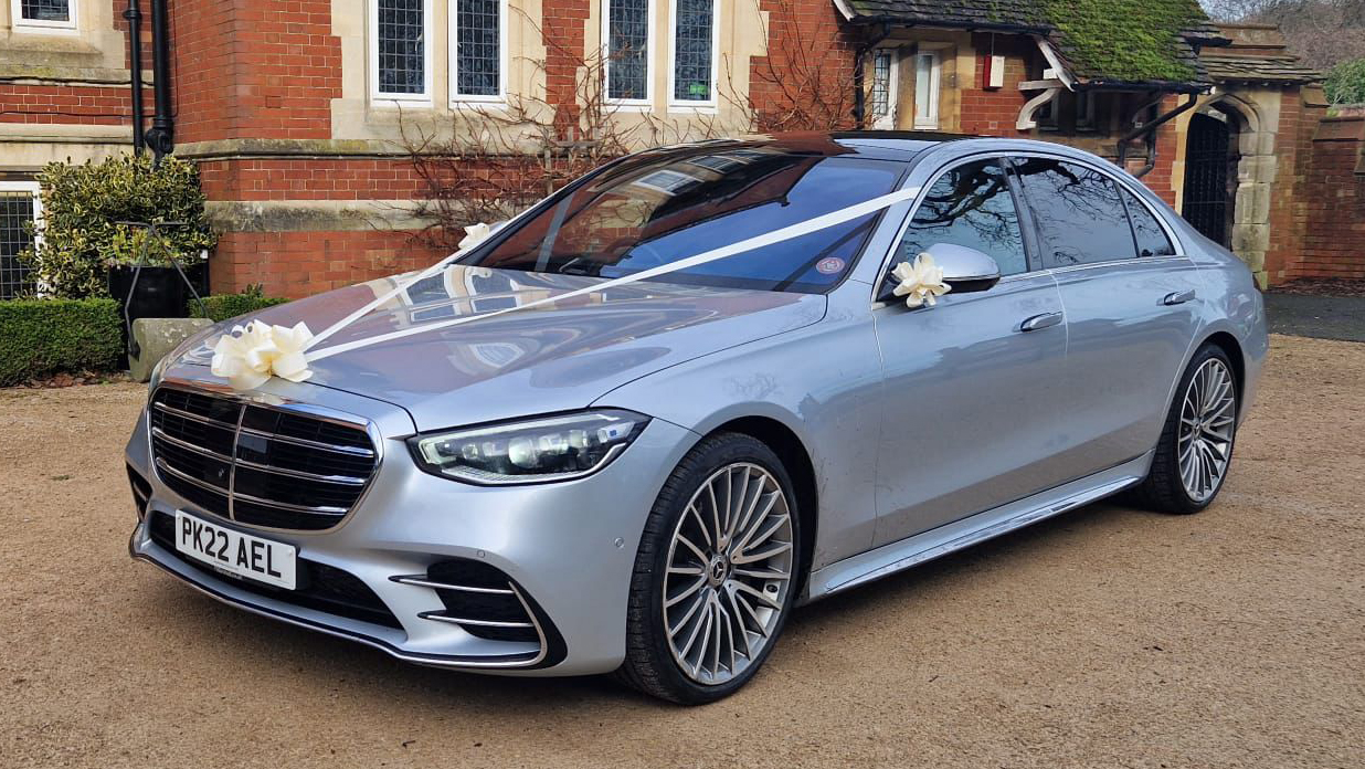 Silver Mercedes S-Class decorated with Ivory Wedding Ribbons and bows on front of venue in Bristol