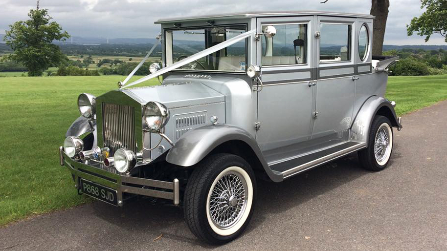 Silver Imperial with white wedding ribbons and white wall tires and soft top convertible roof open