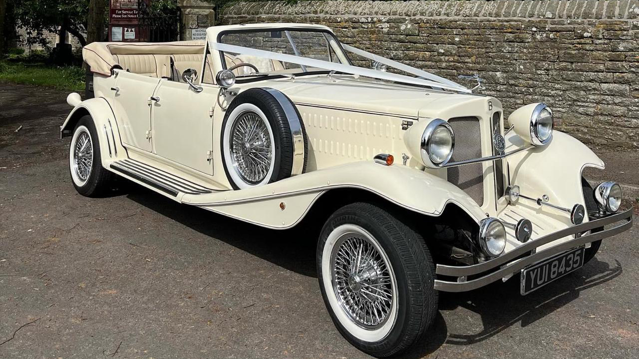 Cream fully convertible Beauford with white ribbons and white wall tires