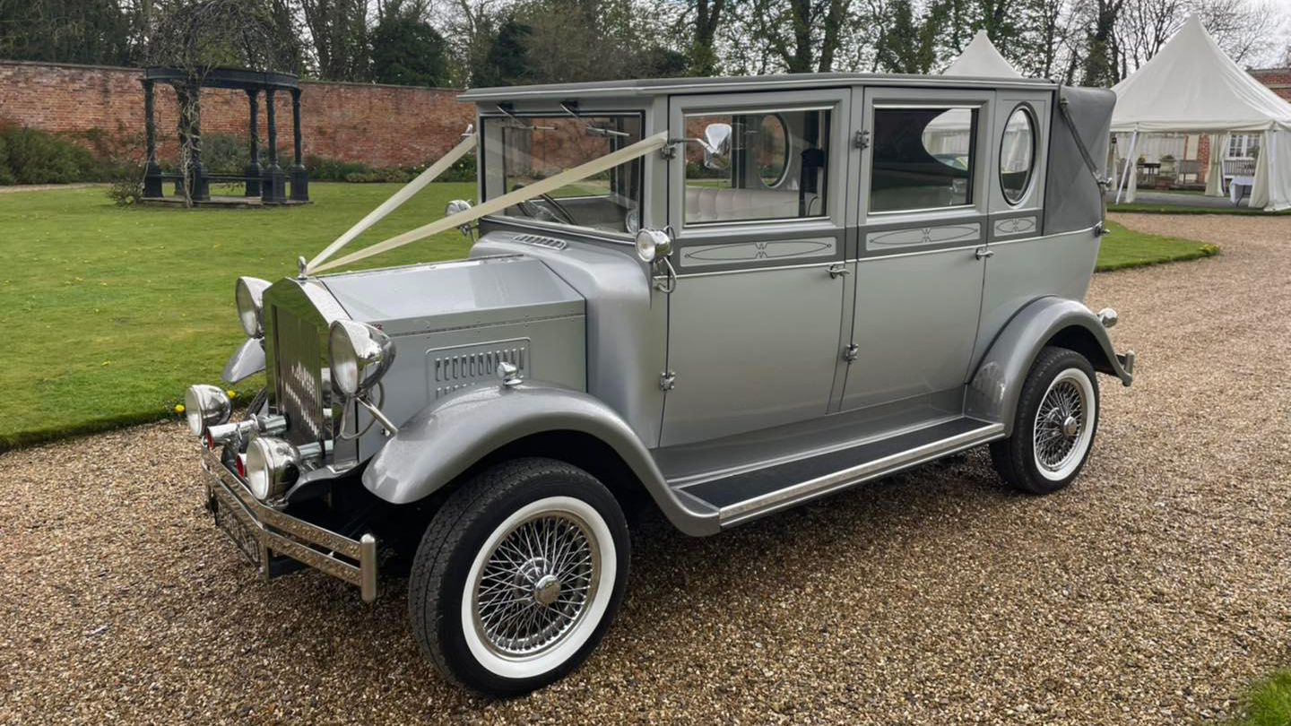 Front left view of Silver vintage imperial wedding car with soft top rear roof closed