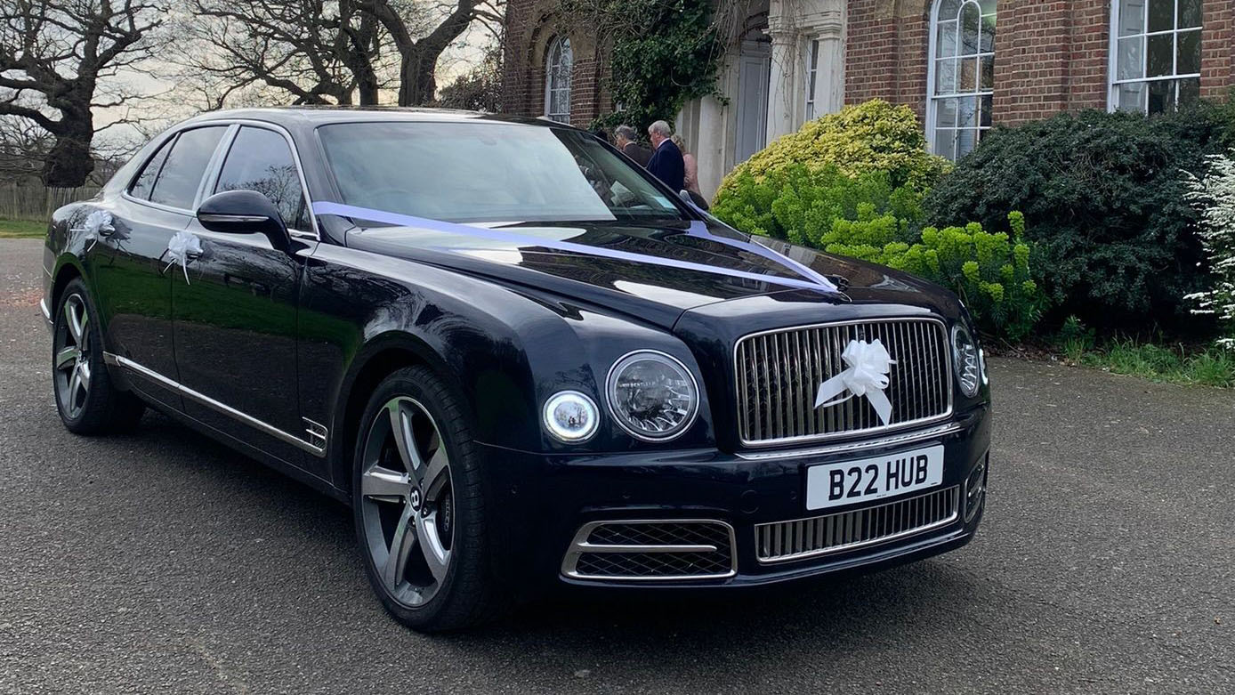 Modern Blue Bentley Mulsanne with a large white bow on its front chrome grill