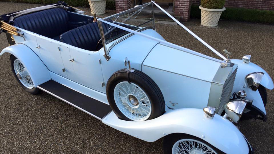 aerial view a white vintage Rolls-Royce with convertible roof open