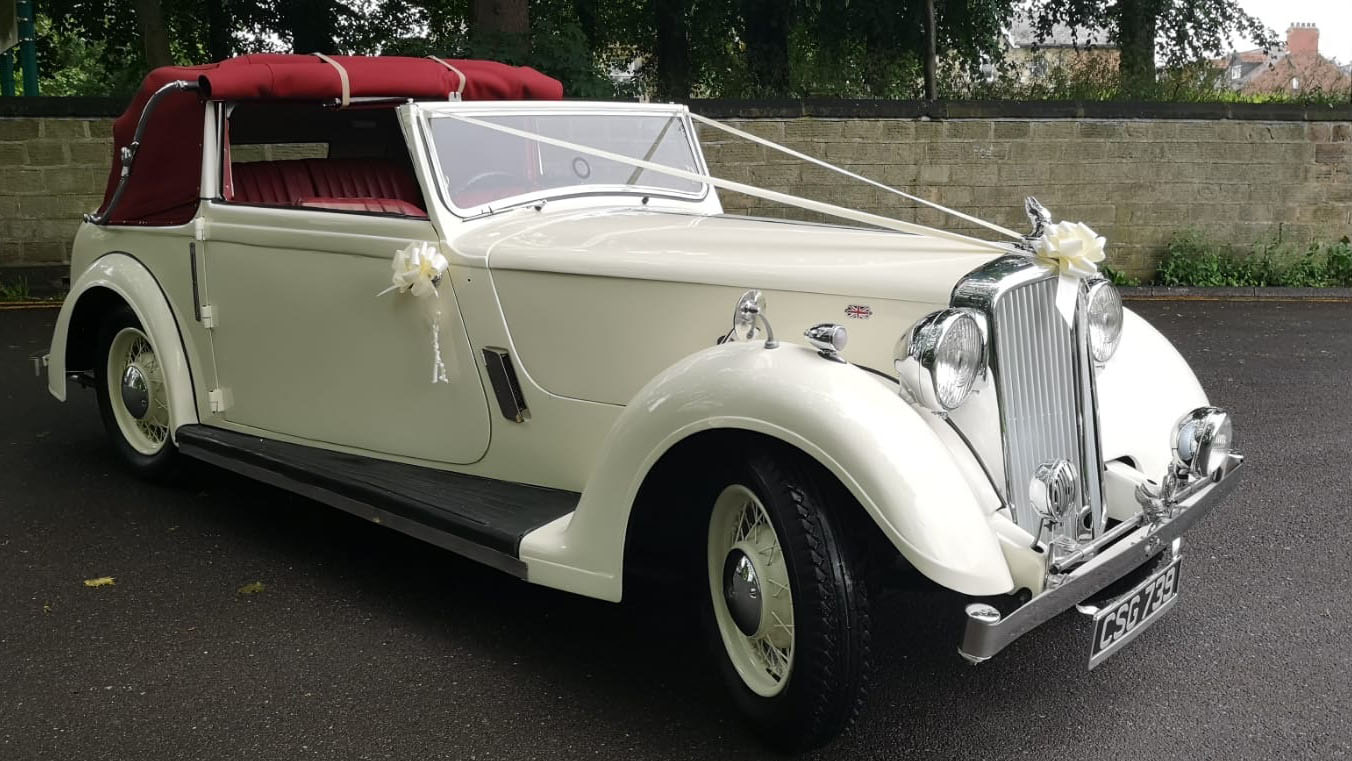 Vintage Tickford decorated with wedding ribbons and burgundy roof semi open