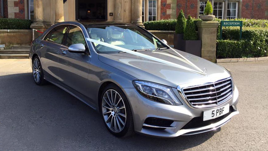 Silver Mercedes with white ribbons dressed with white ribbons