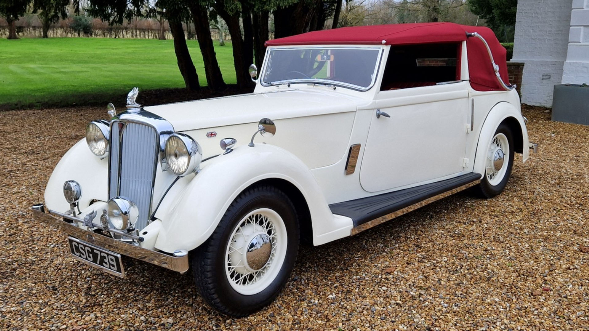 Left side view of a Ivory vintage Rover Tickford with burgundy soft top roof closed