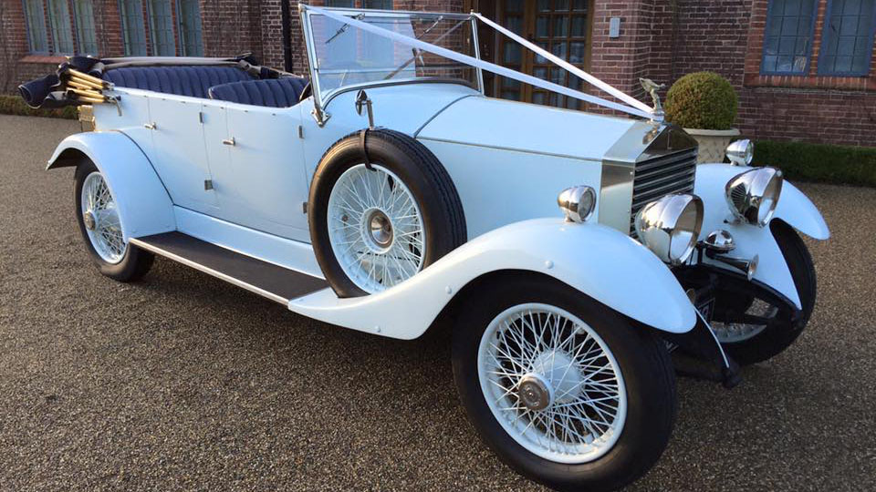 fully-convertible White Rolls-Royce with spare wheel mounted on the side of the vehicle, white spokes wheels