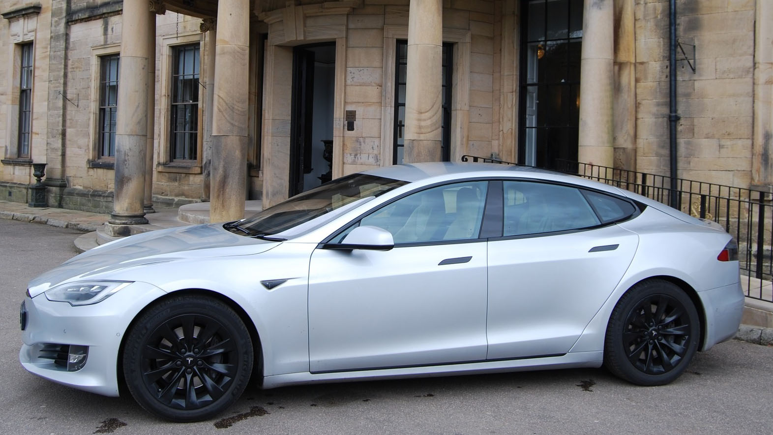 Left side view of a Tesla S in silver with black alloy wheels