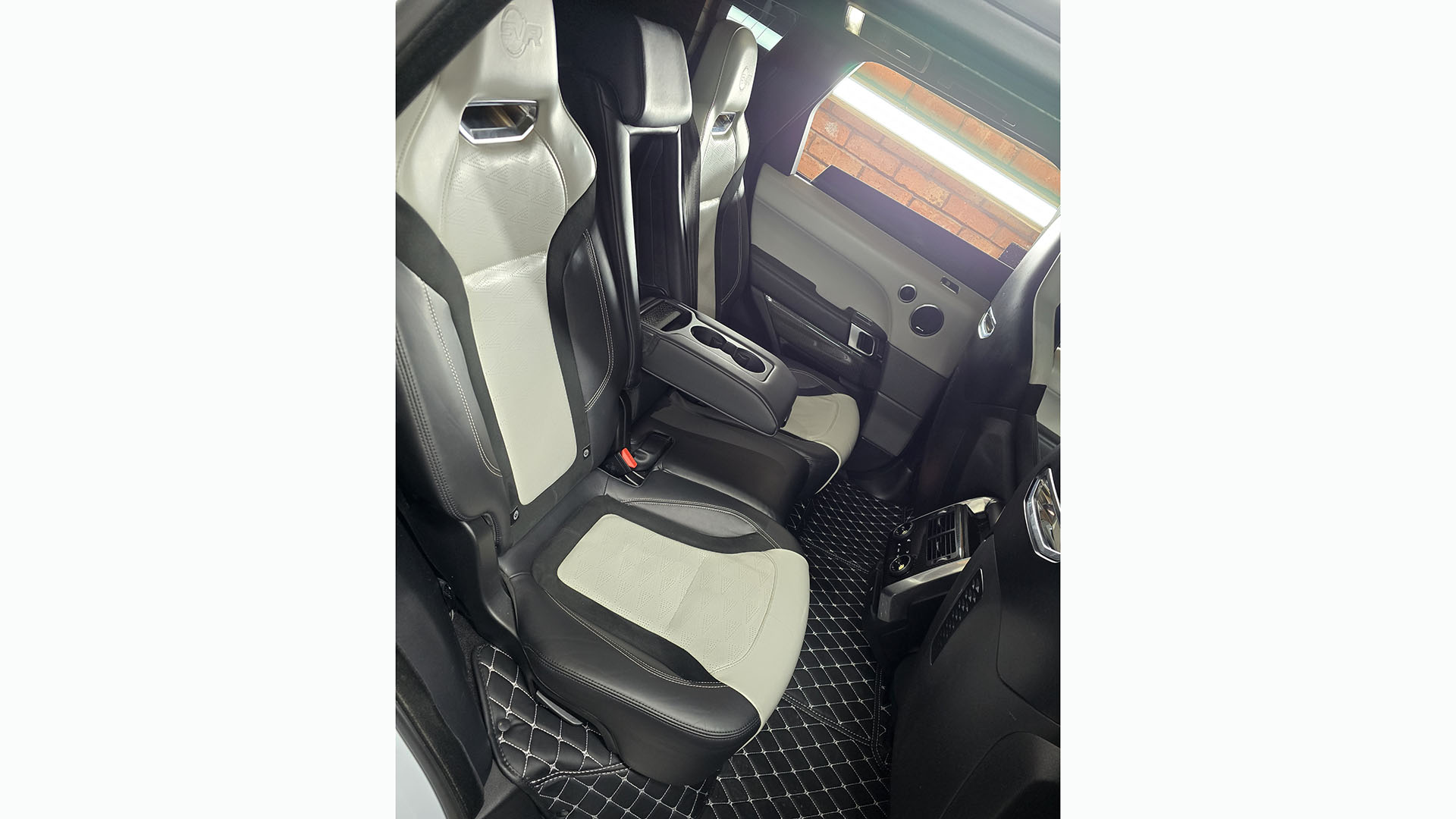 Rear interior seats in black and cream inside Range Rover showing large legroom