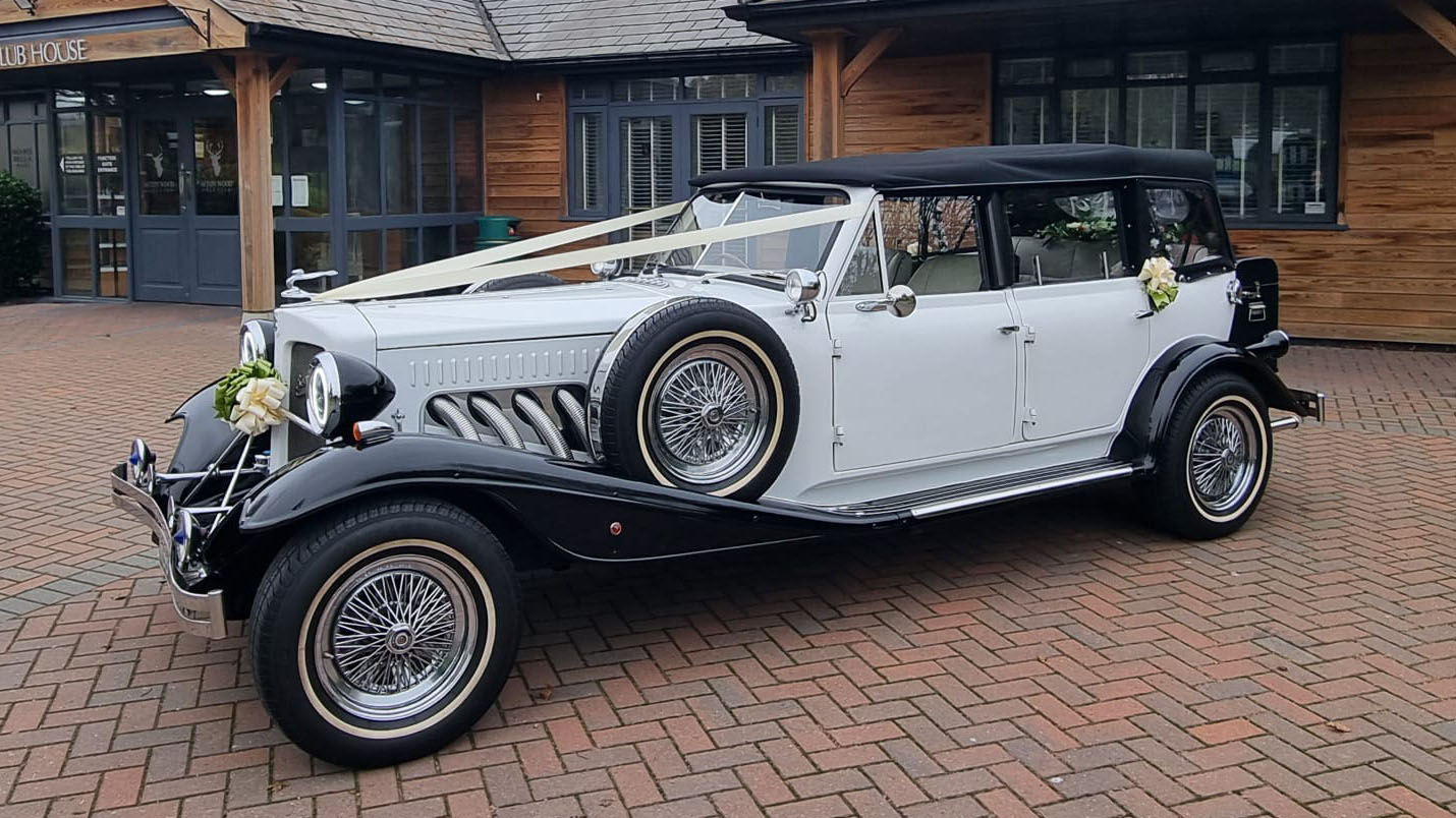 Left side view of Beauford in white with black wheel arches and spare wheel mounted on the side of the vehicle