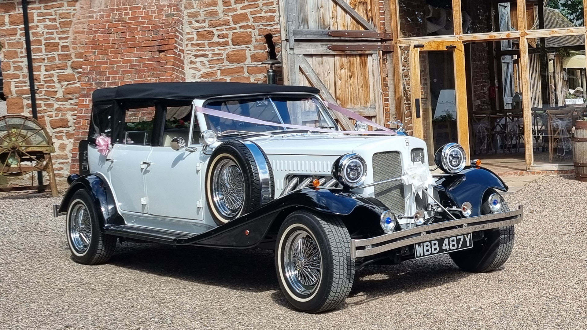 White Beauford with Black wheel arches and black soft top roof parked in front of a wedding venue in West Midlands