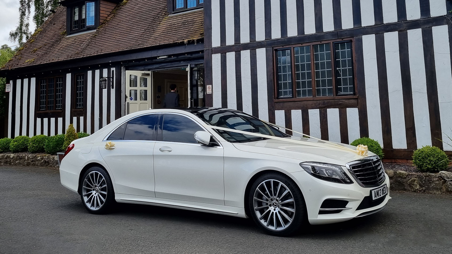 Right side view of white Mercedes S-class with white ribbons and chrome alloy wheels