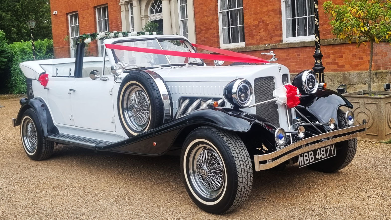 White Beauford with Black Wheel arches decorated with red ribbons and convertible roof open