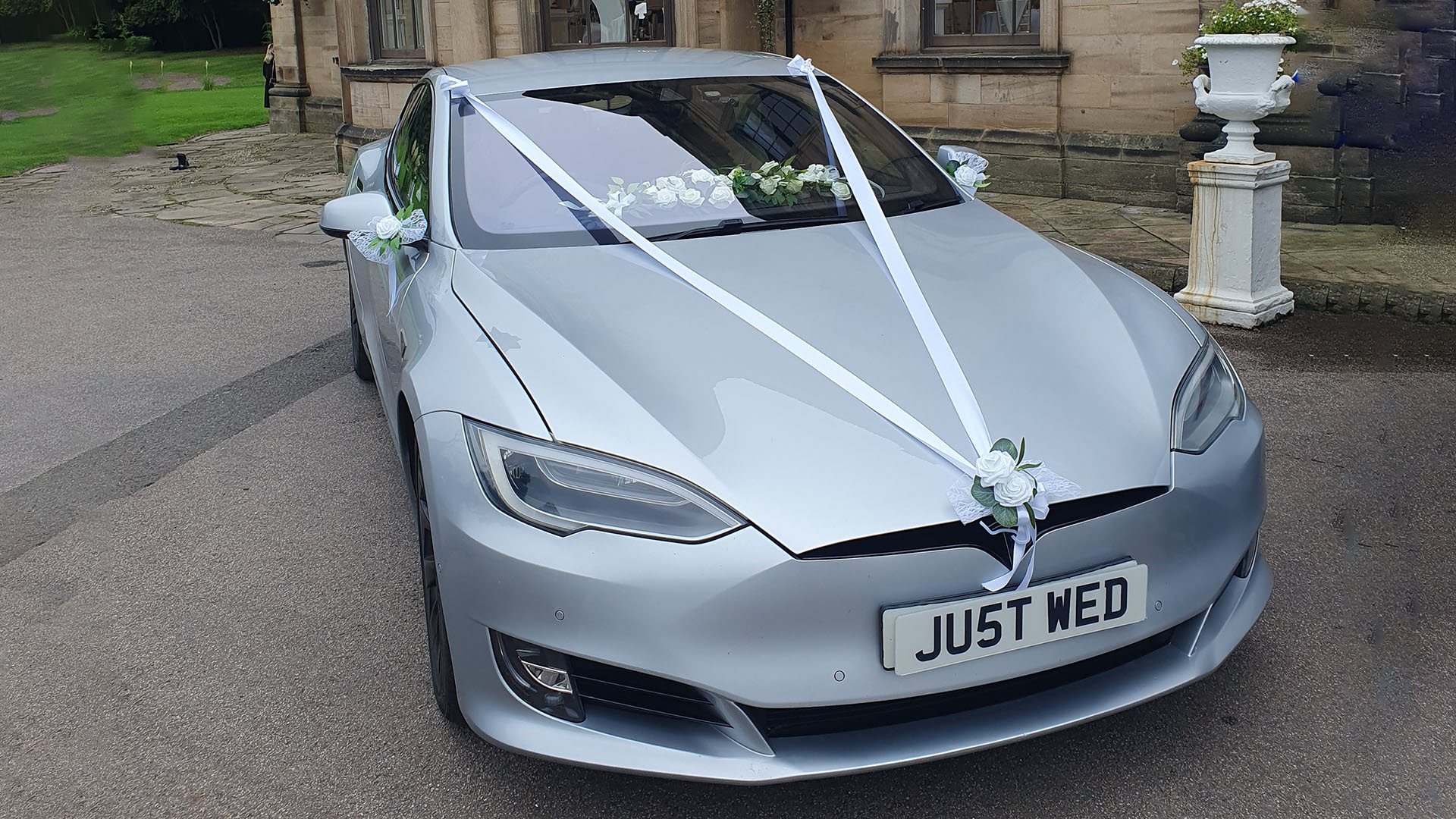 Silver Tesla model S with wedding ribbons and bows