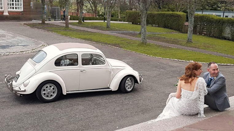 Right side view of Ivory Classic Volkswagen Beetle with Bride and Groom