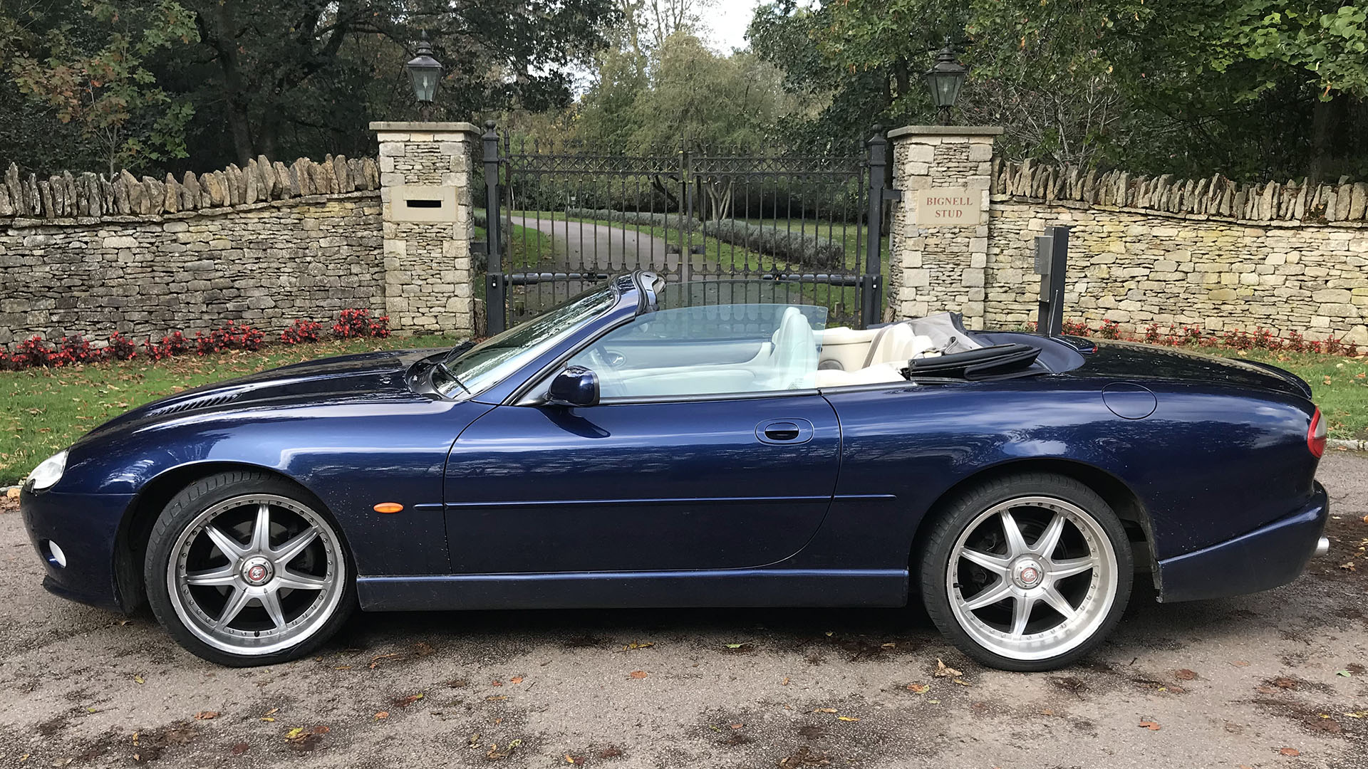 Right side view of blue Jaguar XKR with convertible roof down